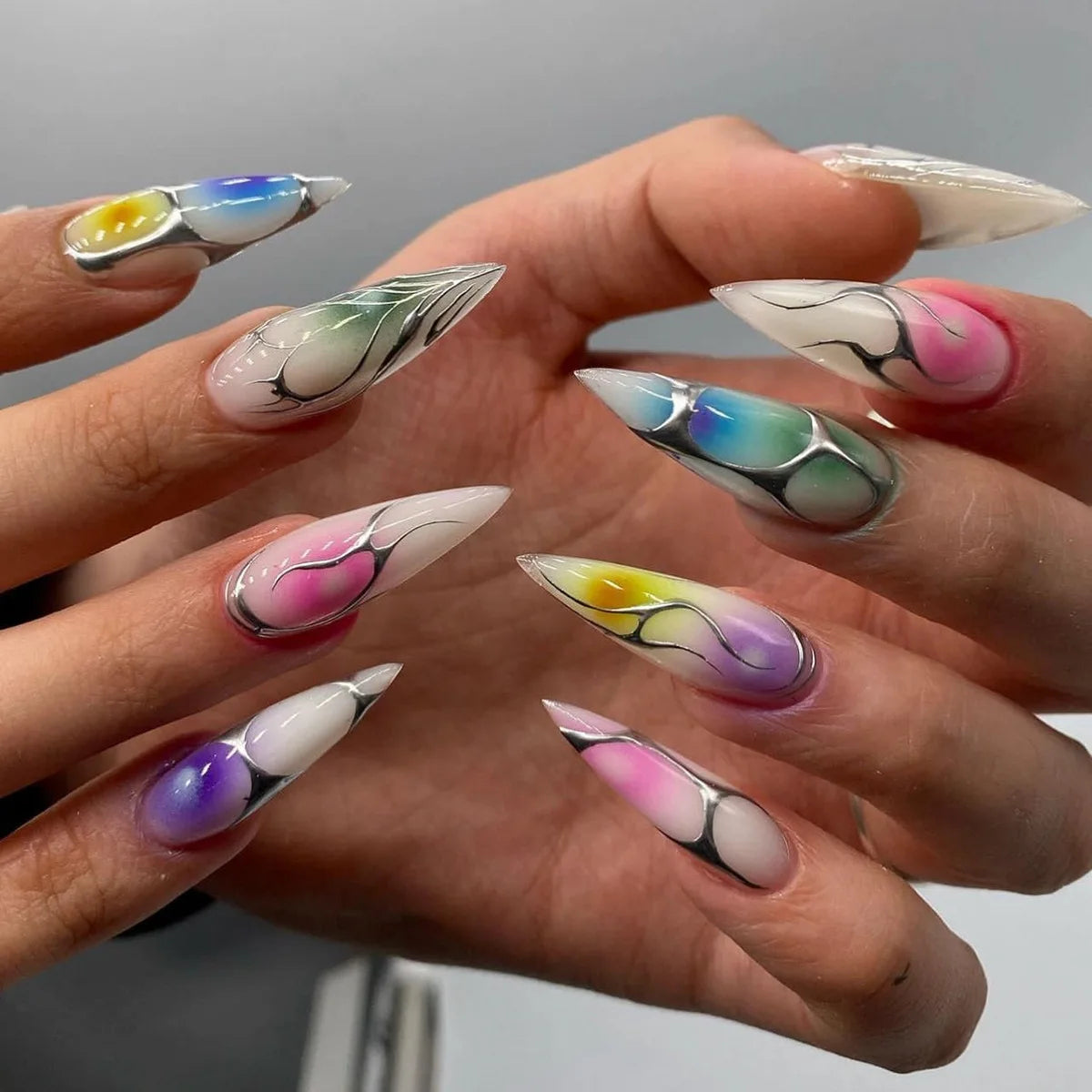 Long decorative nail designs with raised accents shown on hands