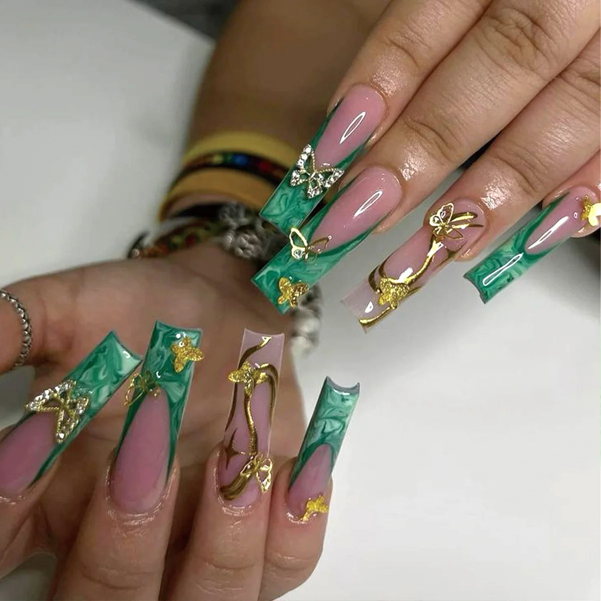 Long decorated nail designs shown on hands