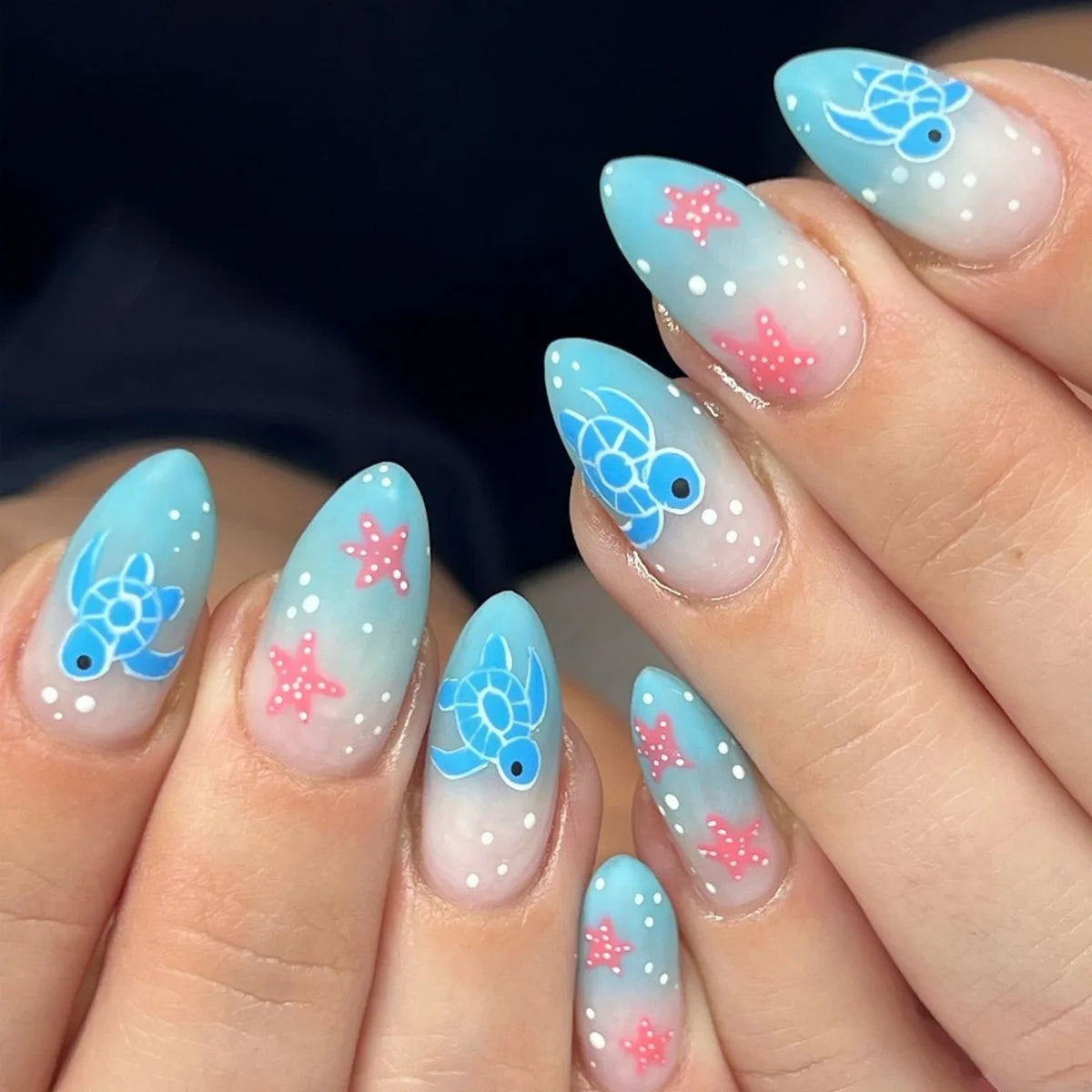 Blue marine-themed nail designs shown on hands