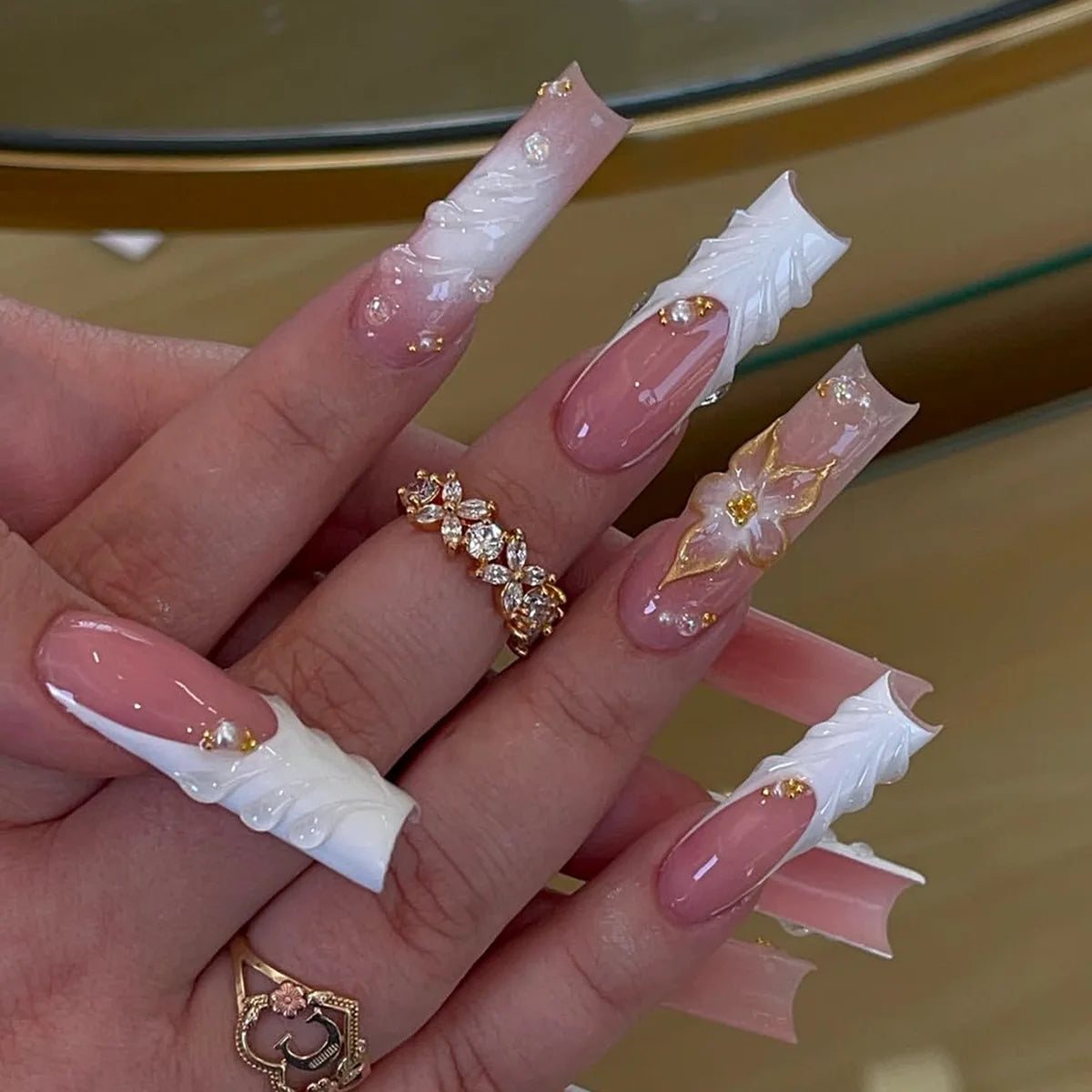 Long decorated nails with raised embellishments shown on hands
