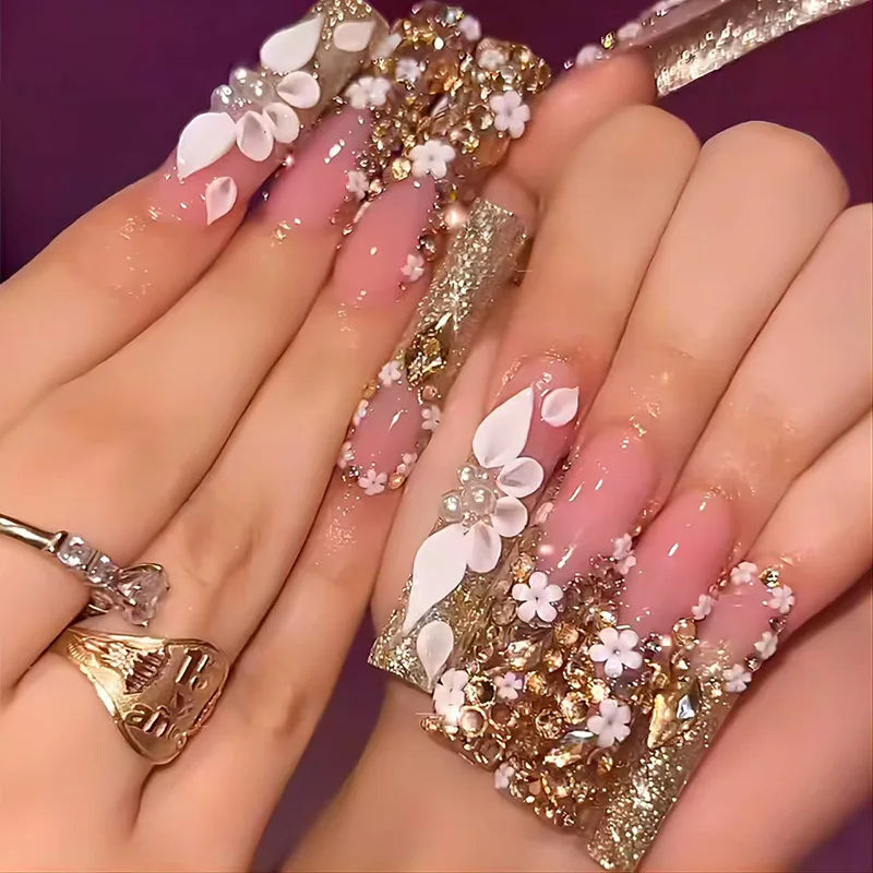 Decorative nail designs with floral, metallic or gem accents shown on hands