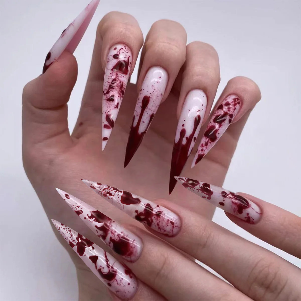 Decorative nail designs with floral, metallic or gem accents shown on hands