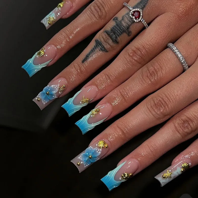 Long decorated nails with raised embellishments shown on hands