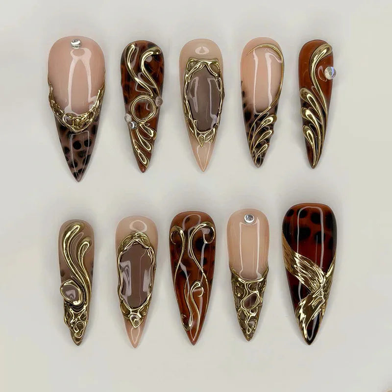 Brown and gold pointed press-on nails arranged in two rows