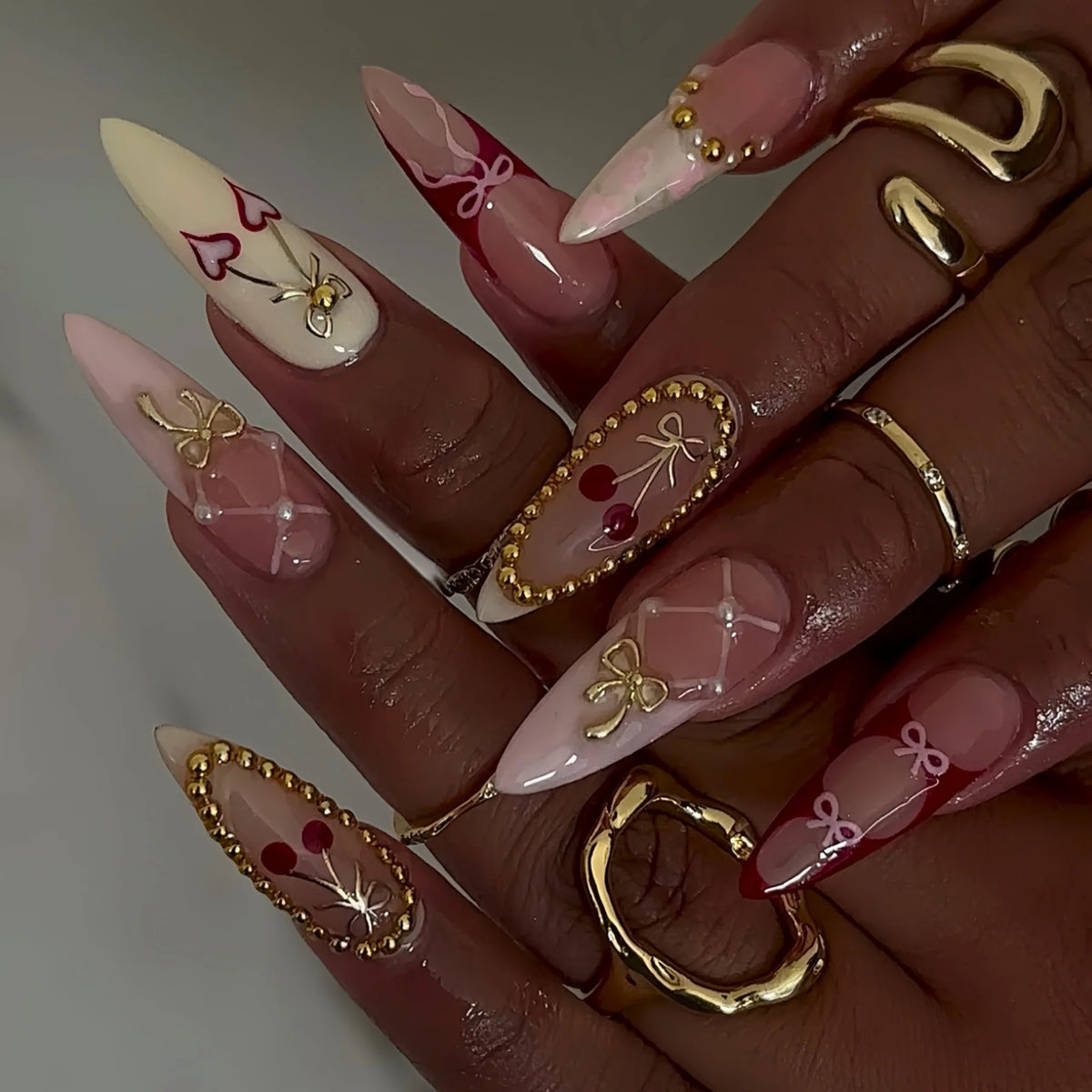 Decorative floral and embellished nail designs shown on hands