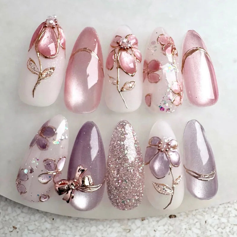 Pink and purple embellished press-on nails arranged in rows