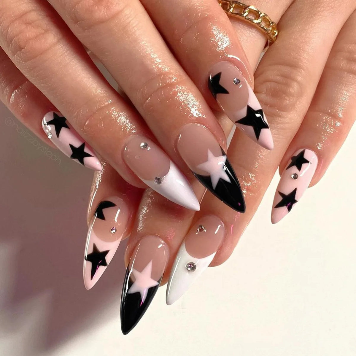 Long black and white decorative nails shown on hands
