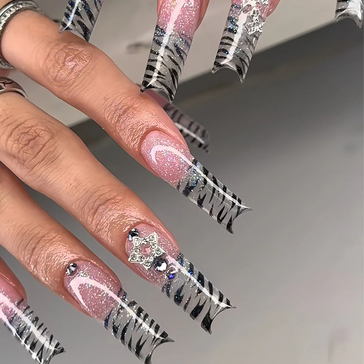 Long decorated nails with raised embellishments shown on hands
