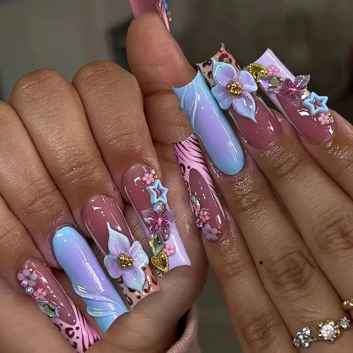 Long decorated nails with raised embellishments shown on hands