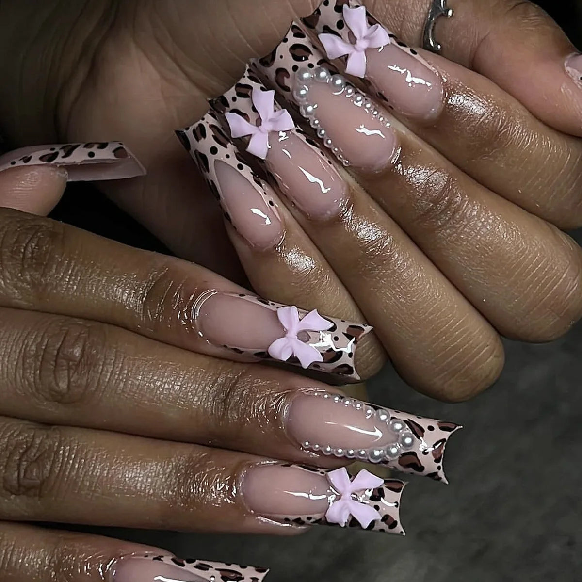 Long decorated nails with raised embellishments shown on hands
