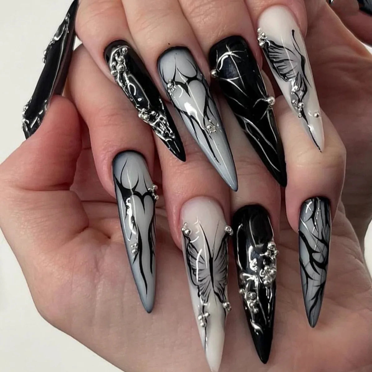 Long decorative nail designs with raised accents shown on hands
