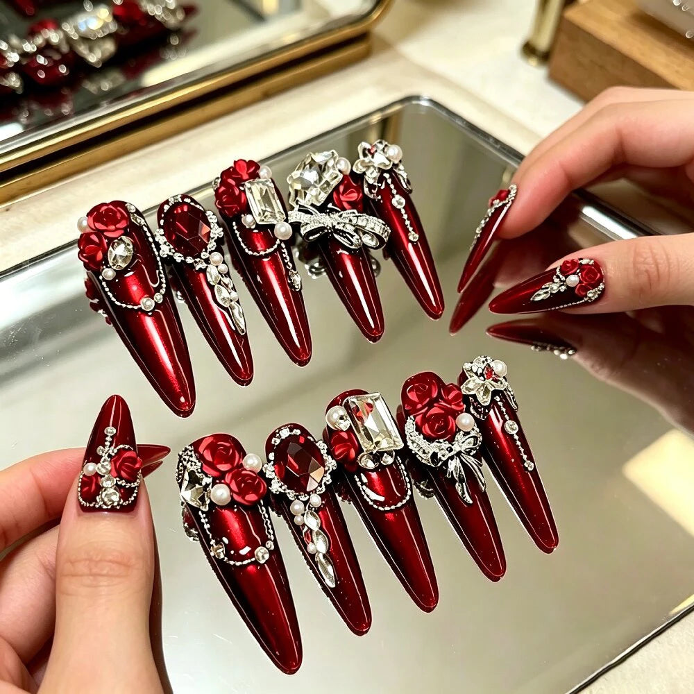 Red gem-encrusted press-on nail set with manicure example