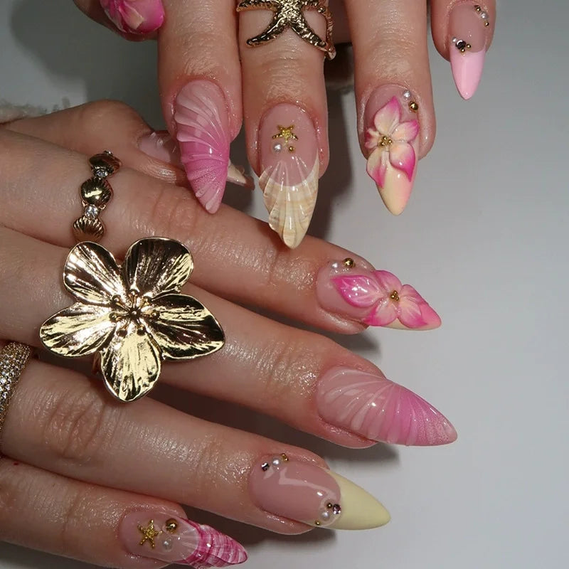 Decorative floral and embellished nail designs shown on hands