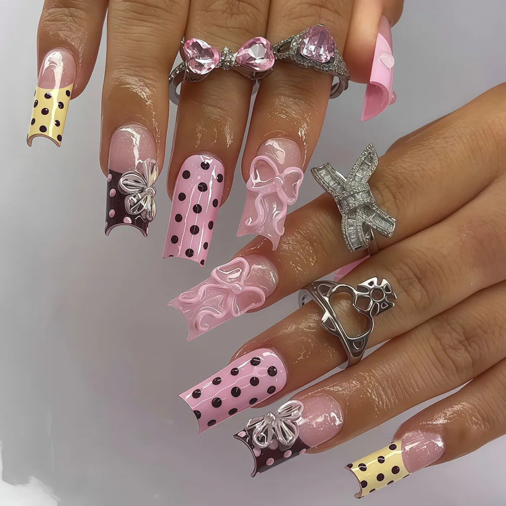 Long decorated nails with raised embellishments shown on hands