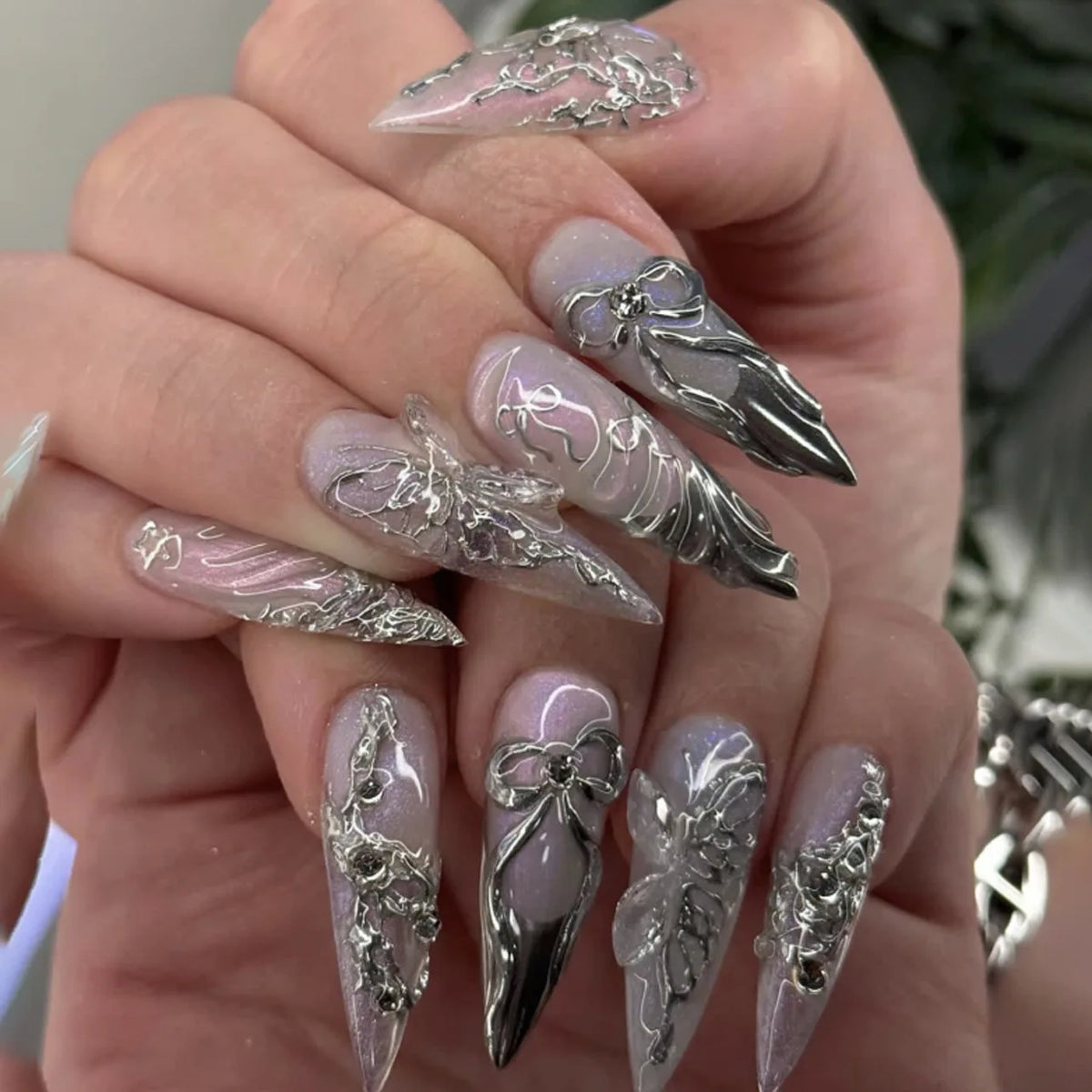 Metallic and embellished nails shown on hands