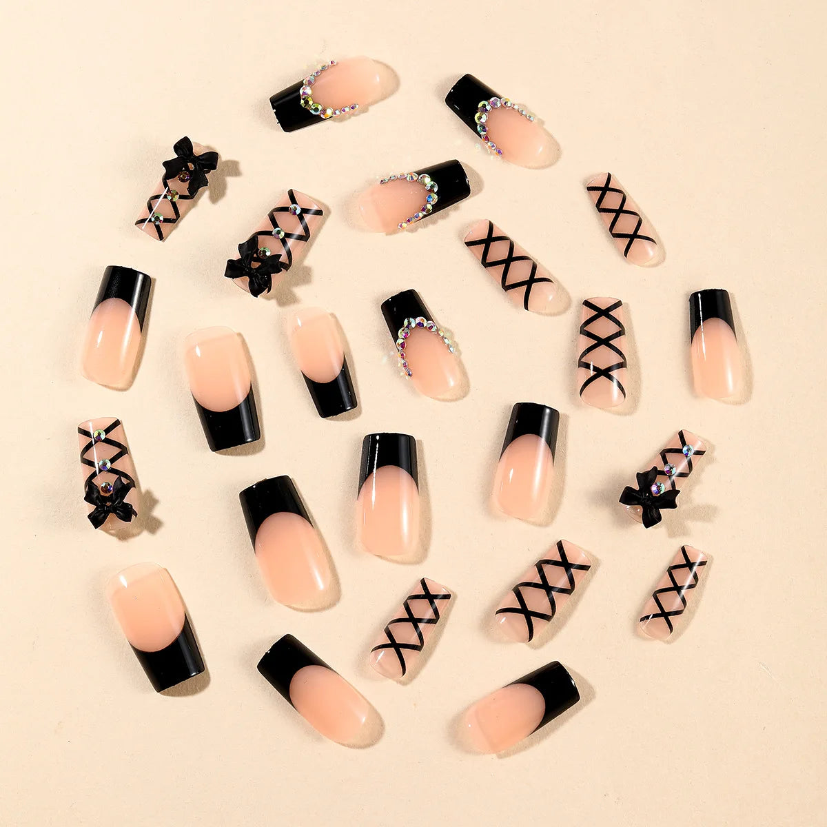 Black and nude press-on nails with decorative accents arranged as a set