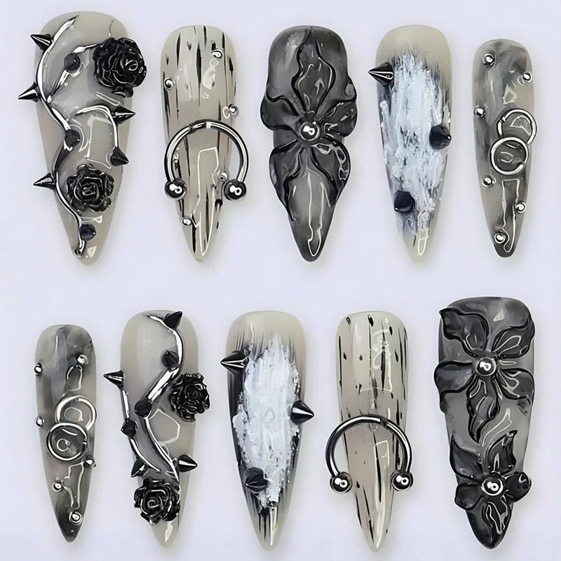 Black and white press-on nails with raised decorations arranged in rows