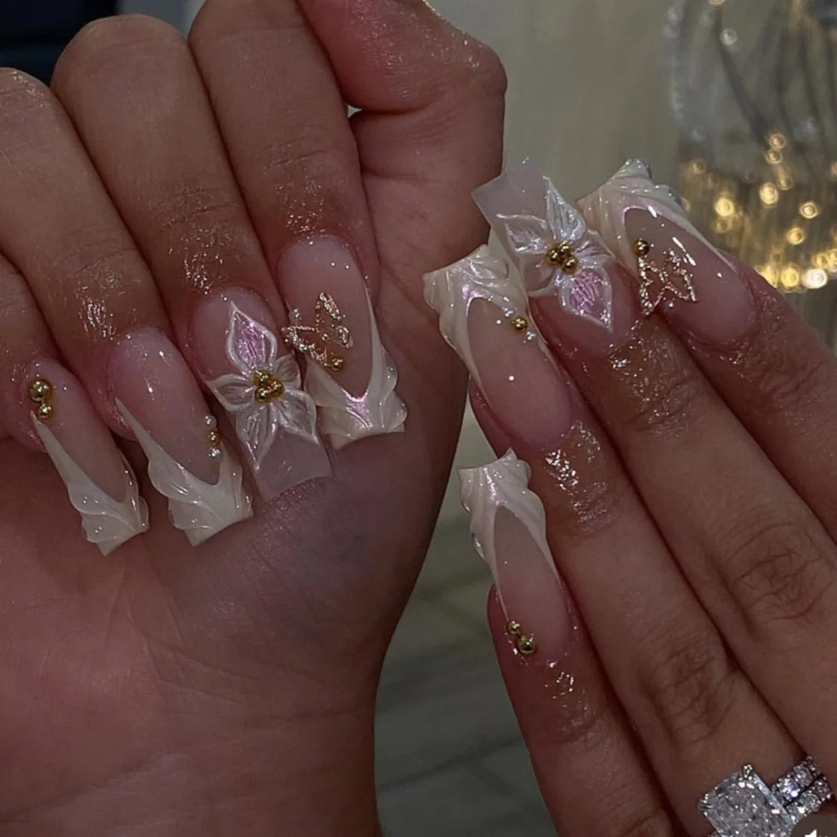 Long decorated nails with raised embellishments shown on hands
