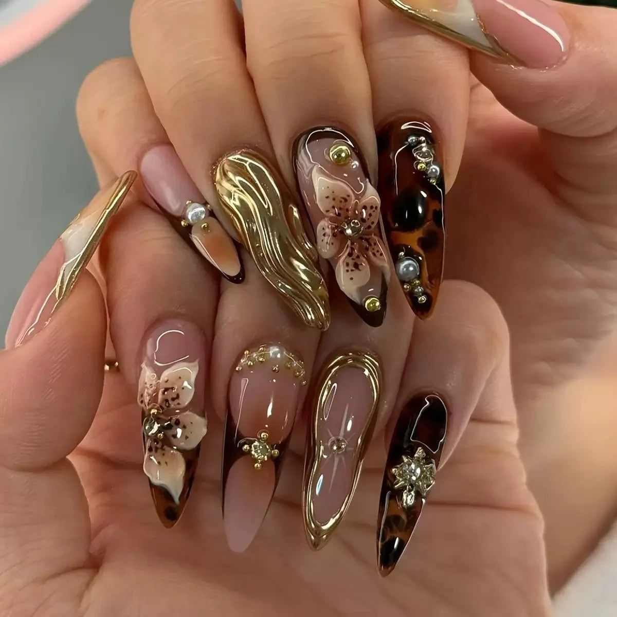 Long embellished pointed nail designs shown on hands