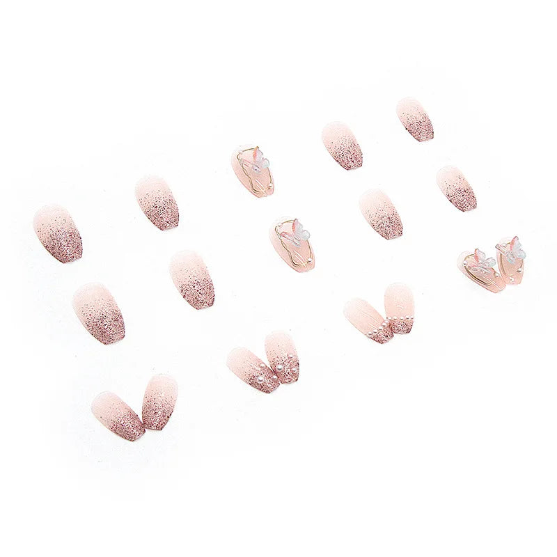 Pink decorated press-on nails arranged on a white background