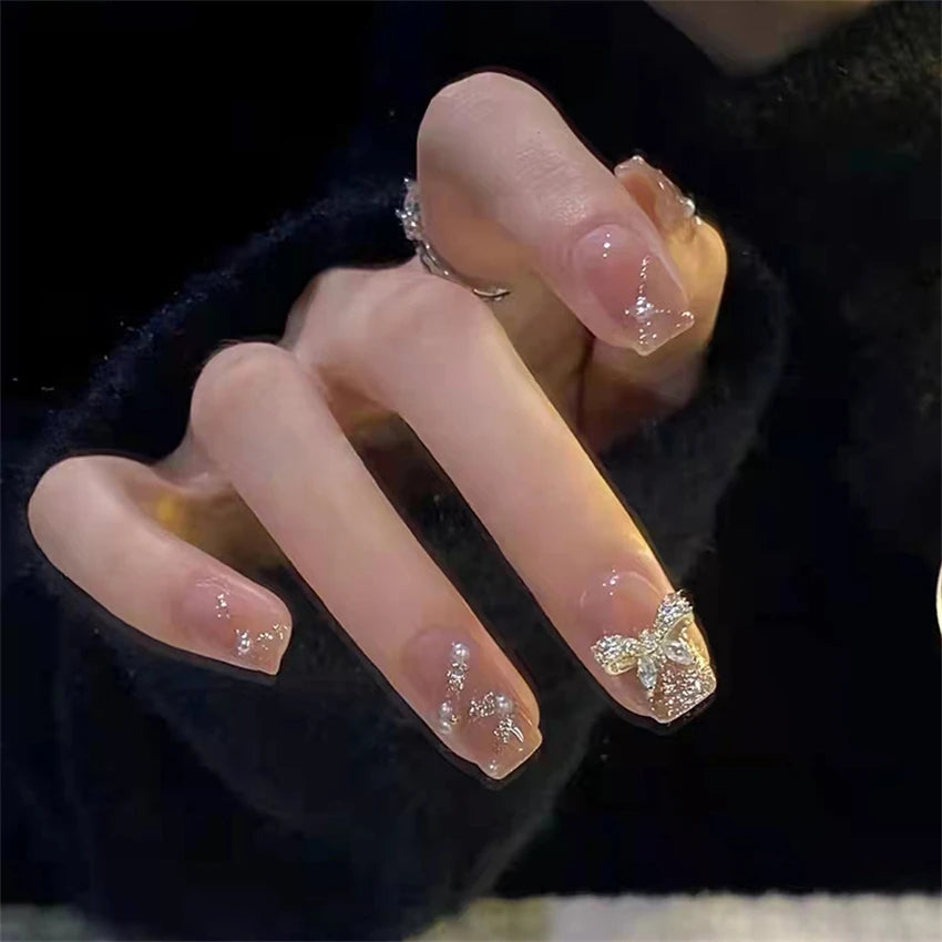Translucent pink nails with gold accents shown on a hand