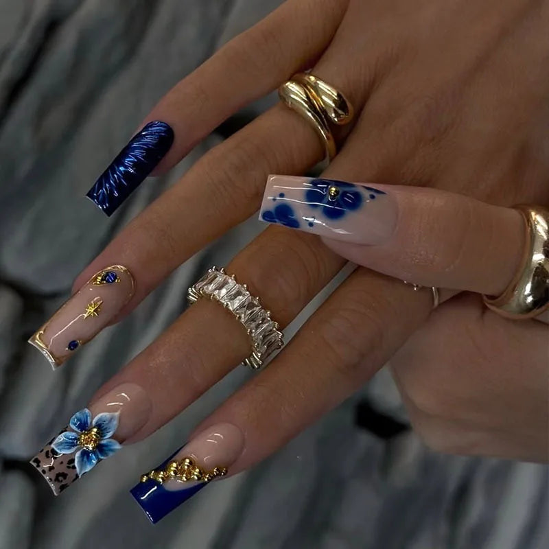 Decorative nail designs with floral, metallic or gem accents shown on hands