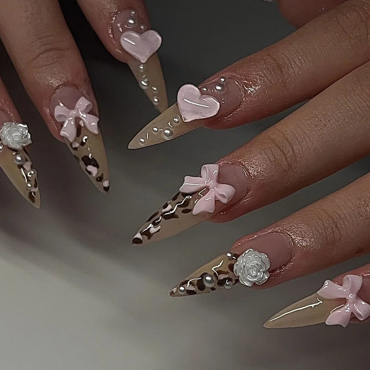 Long decorative nail designs with raised accents shown on hands