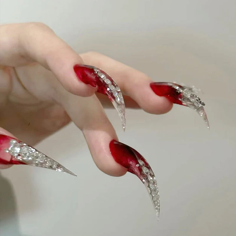 Long red pointed nails shown on a hand