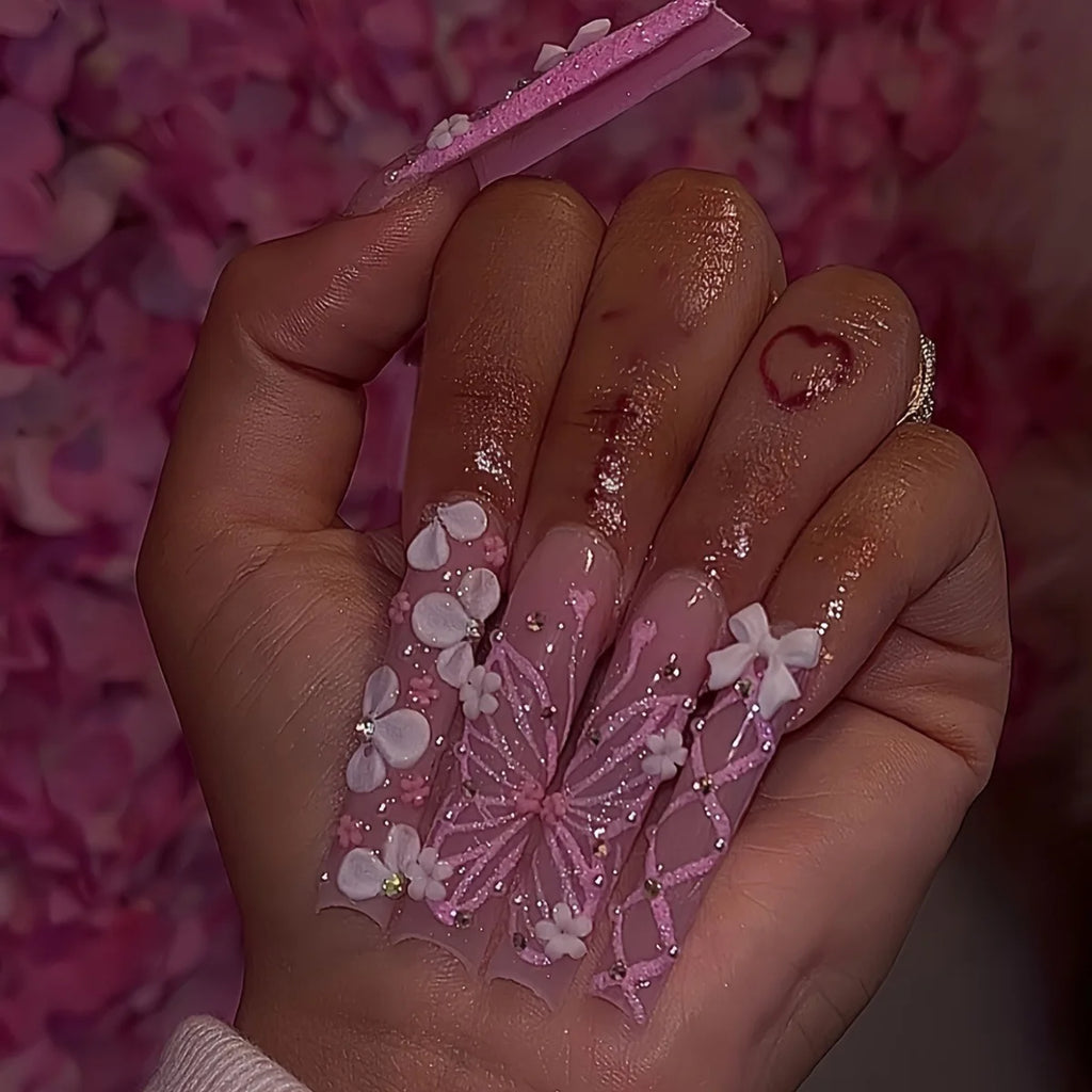 Long decorated nails with raised embellishments shown on hands