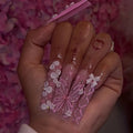 Long decorated nails with raised embellishments shown on hands
