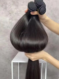 Straight dark hair bundles held up to show their length