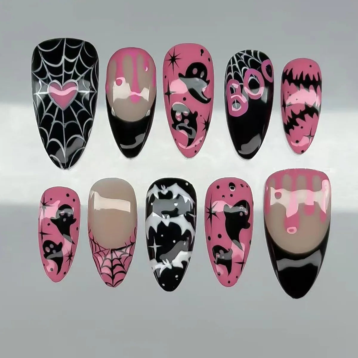 Dark decorated press-on nails arranged in rows