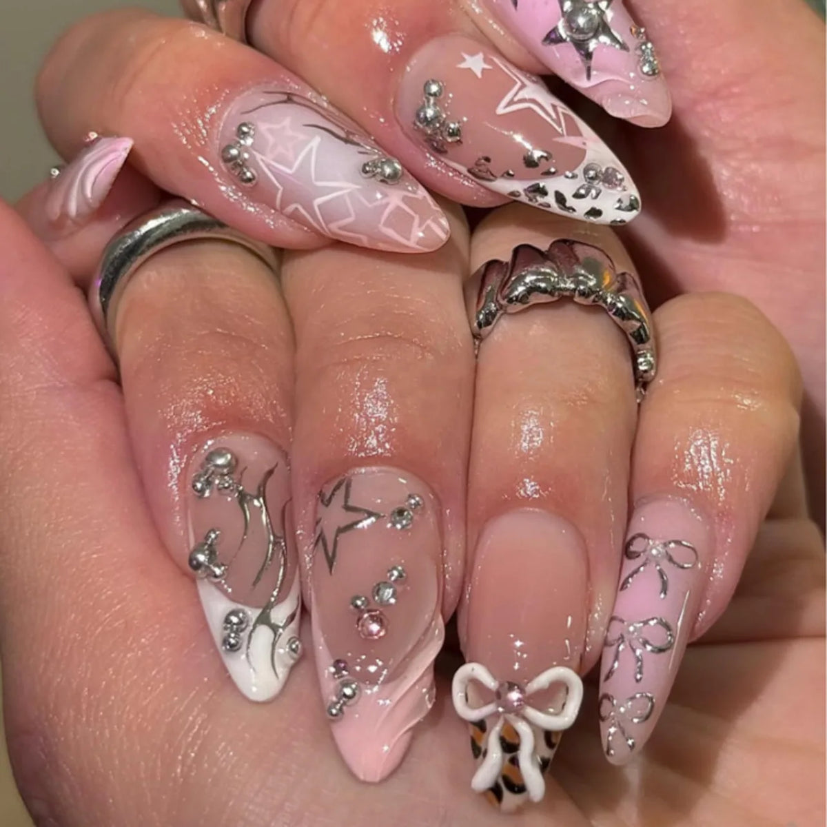 Long decorative nail designs with raised embellishments shown on hands