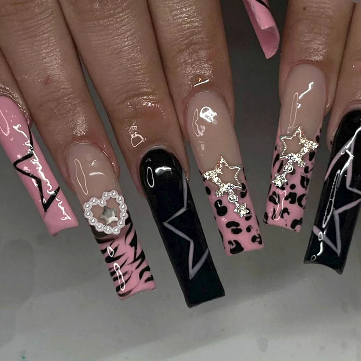 Long decorated nail designs shown on hands