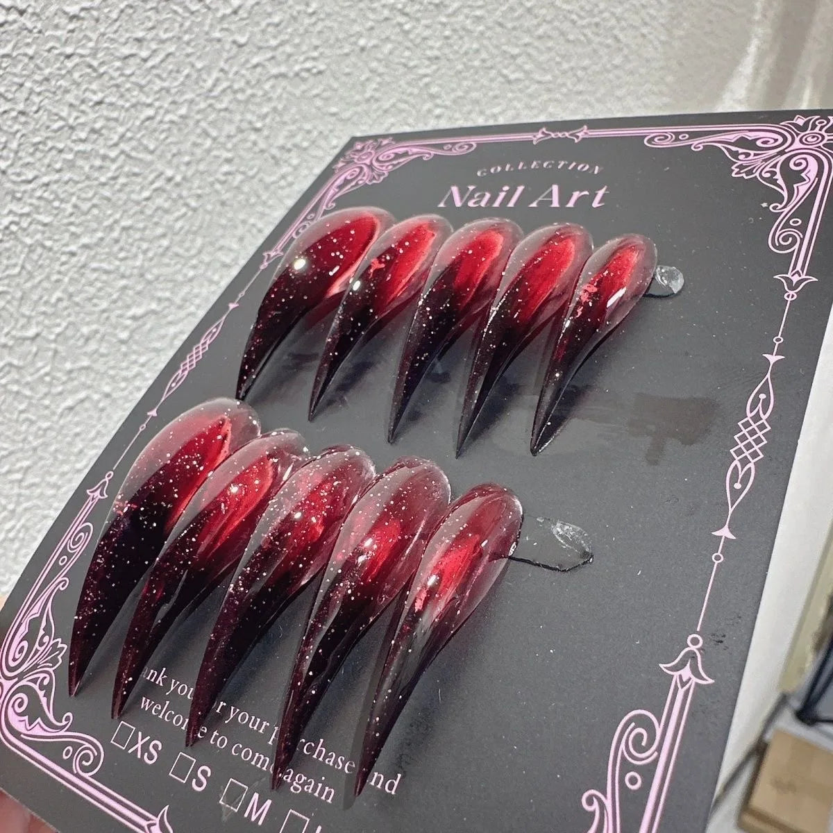 Decorated pointed press-on nails arranged in two rows