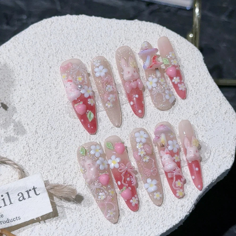 Decorated press-on nail sets with raised embellishments on display cards