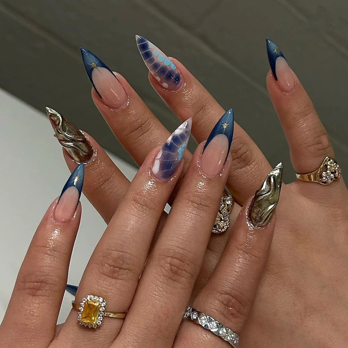 Long pointed decorative nails shown on hands