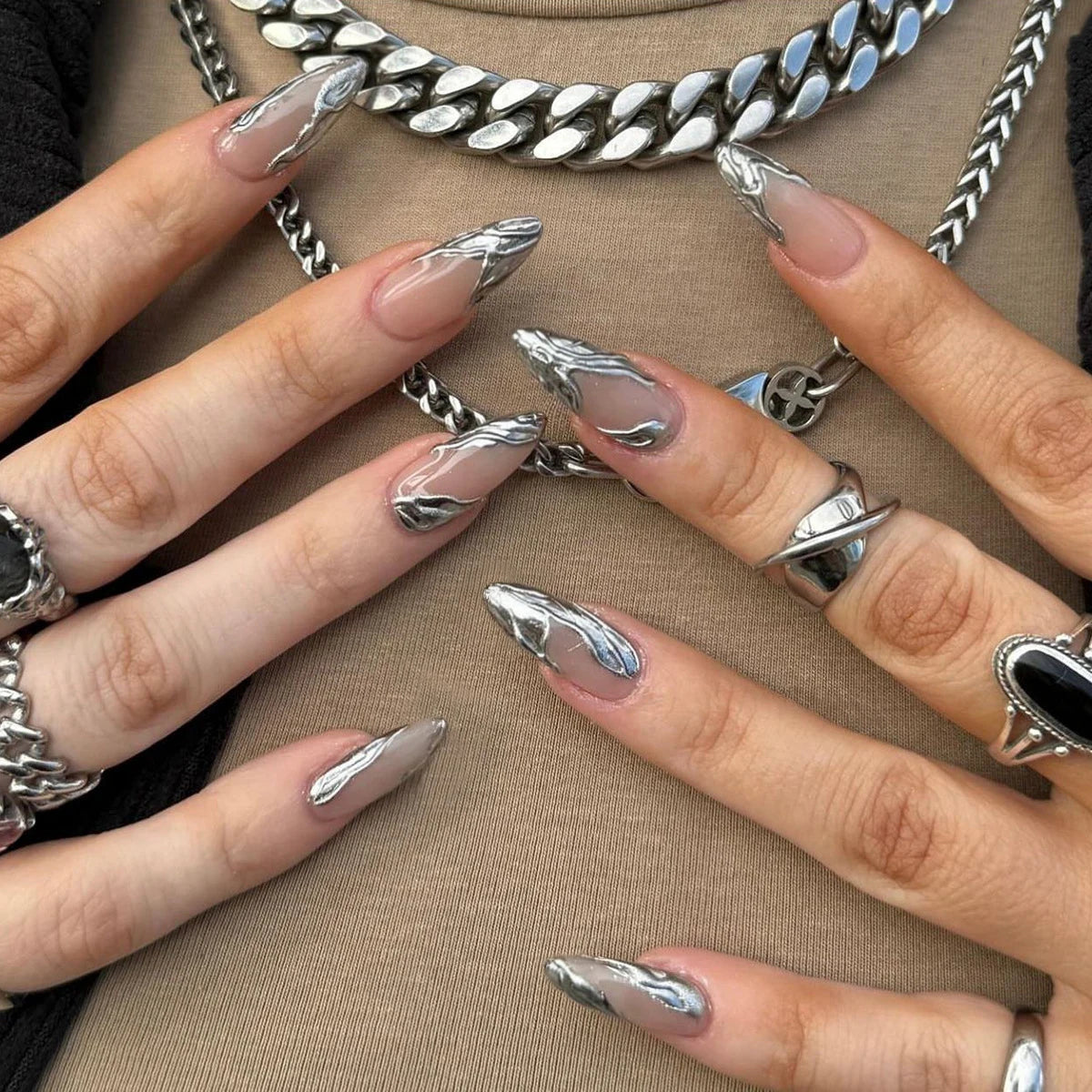 Metallic and embellished nails shown on hands