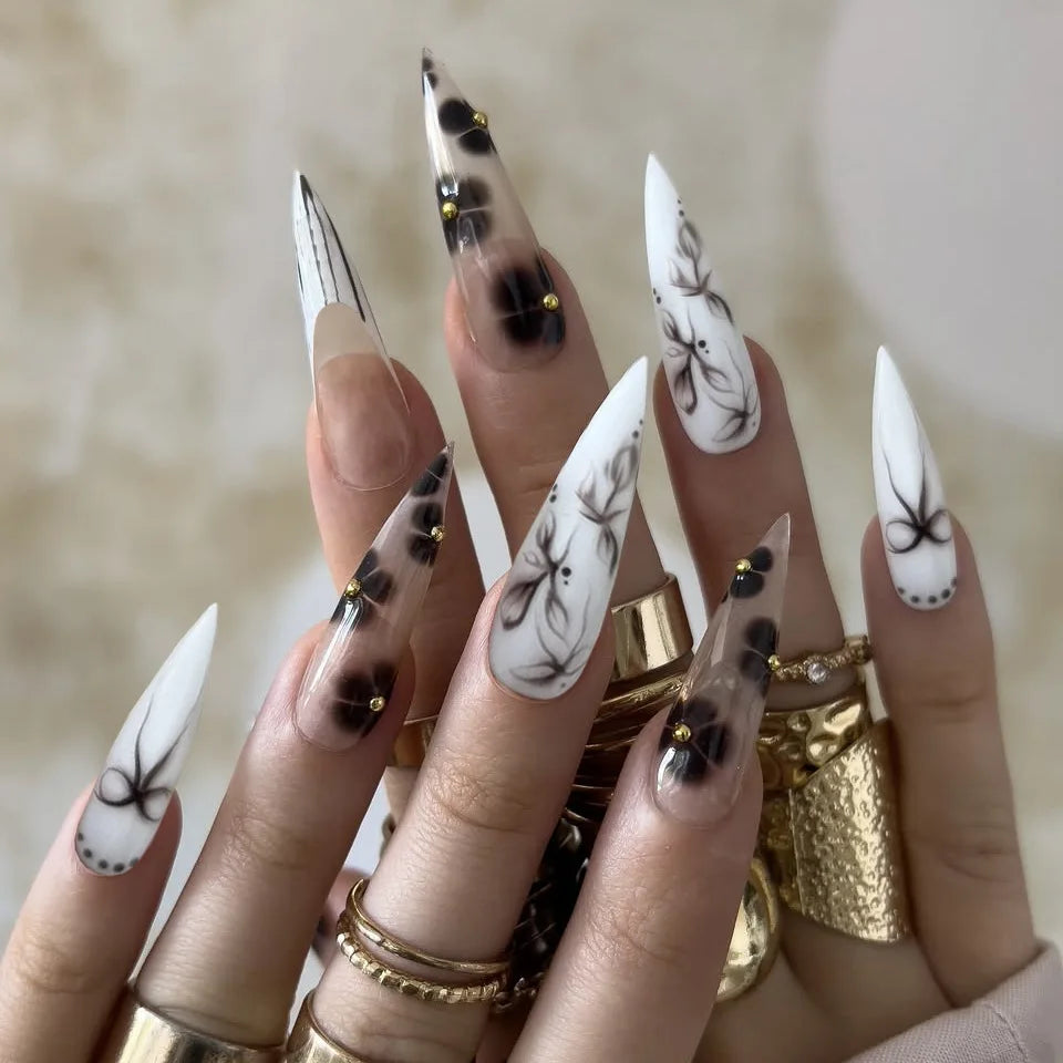 Long black and white decorative nails shown on hands