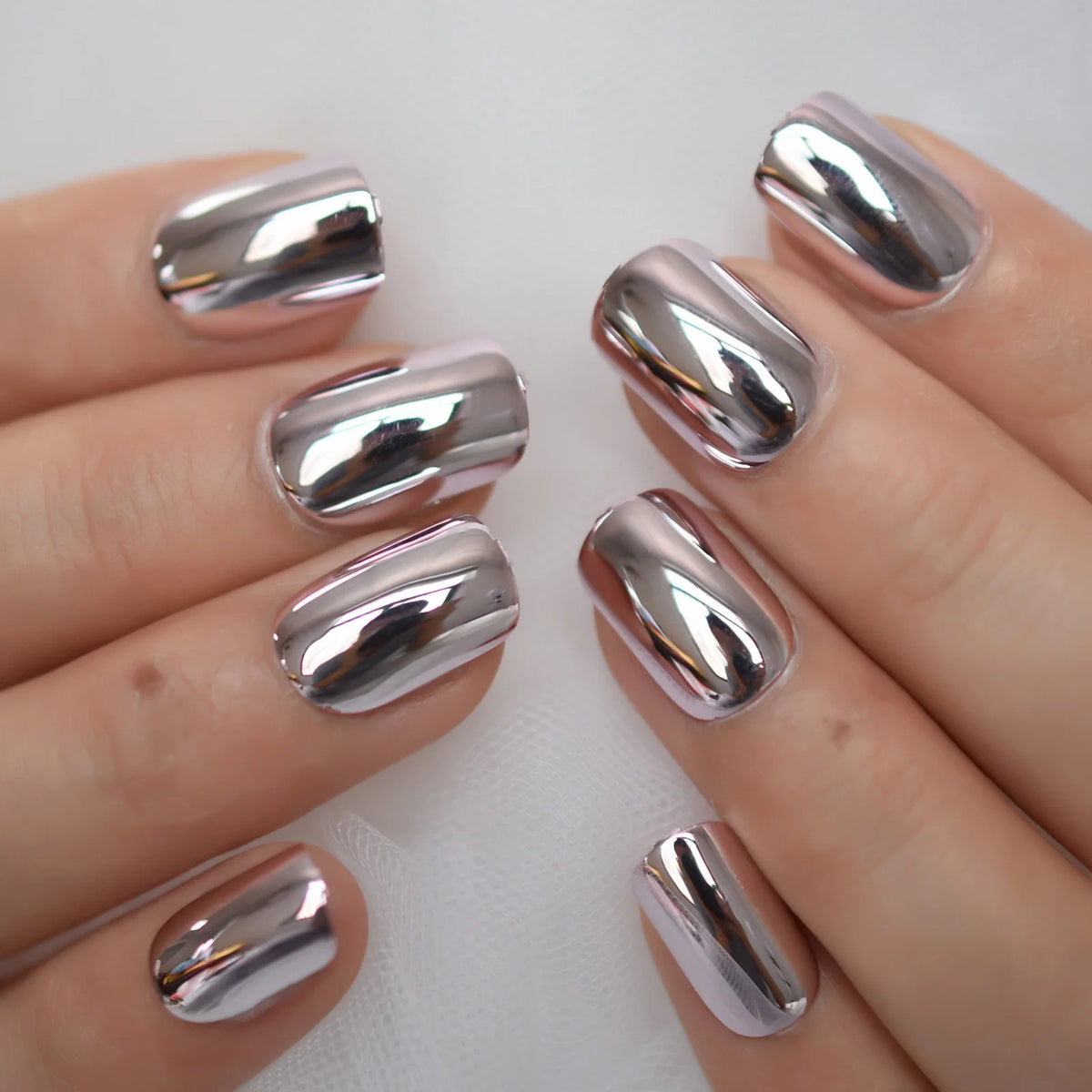 Chrome-finish nails shown on hands
