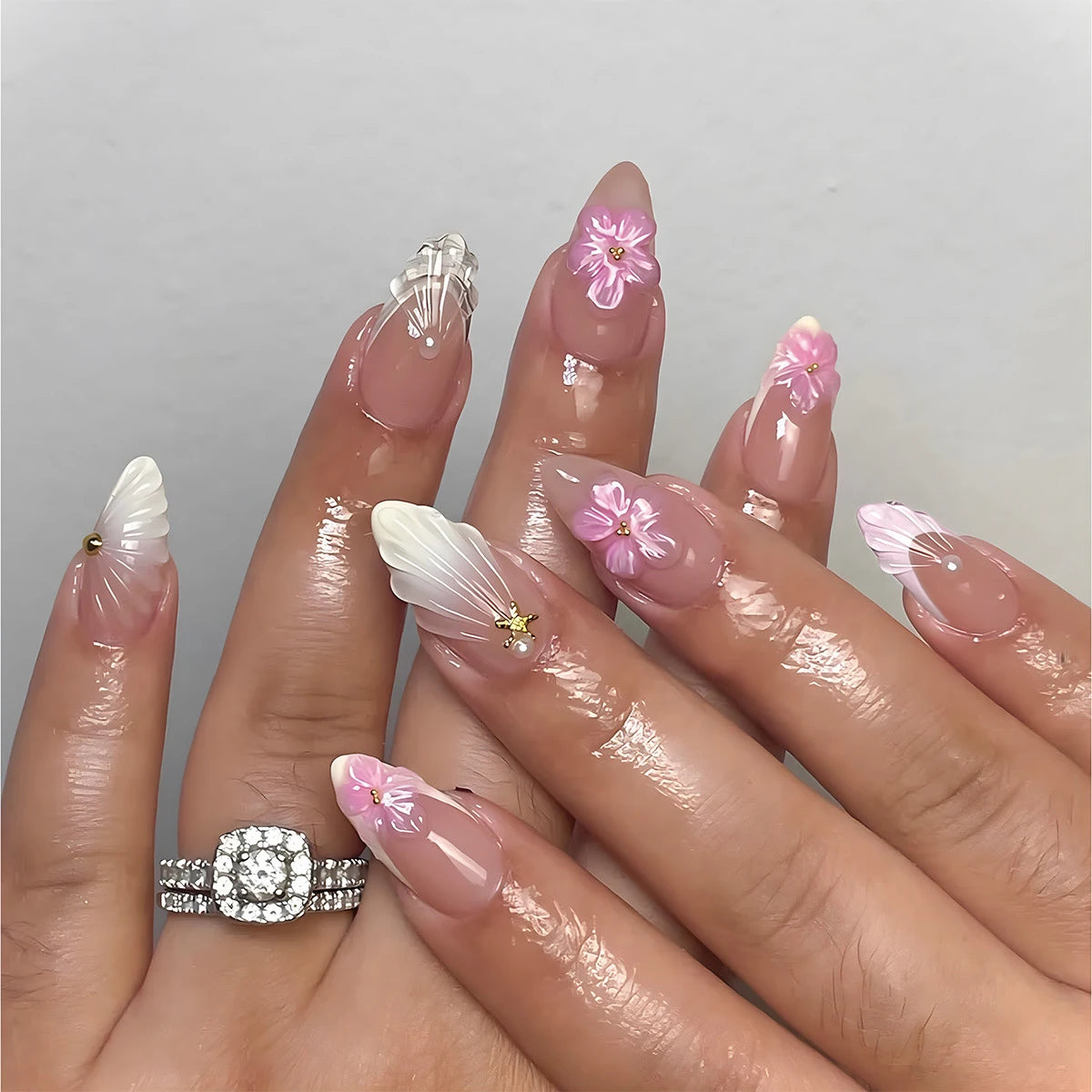 Pink floral nail designs shown on hands