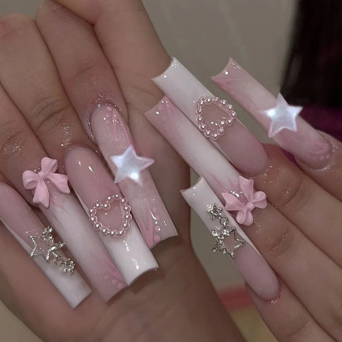Long decorated nail designs shown on hands
