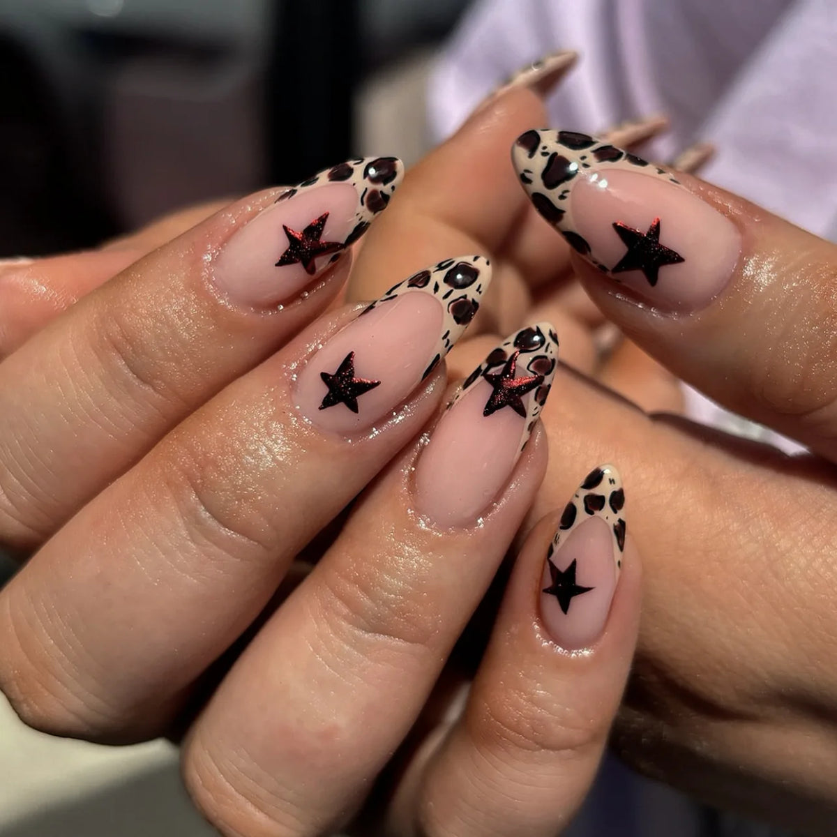 Long decorative nail designs with raised accents shown on hands