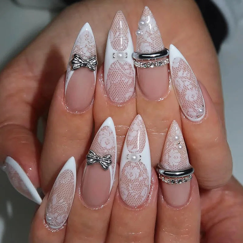 Long embellished pointed nail designs shown on hands