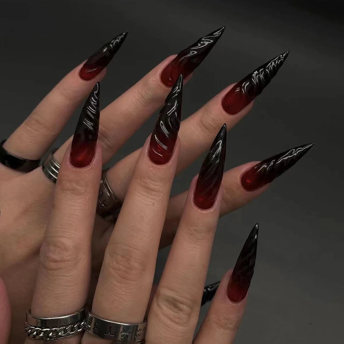 Long decorative nail designs with raised accents shown on hands