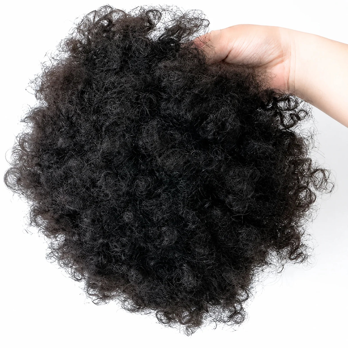 Close-up of curly hair topper held in a hand