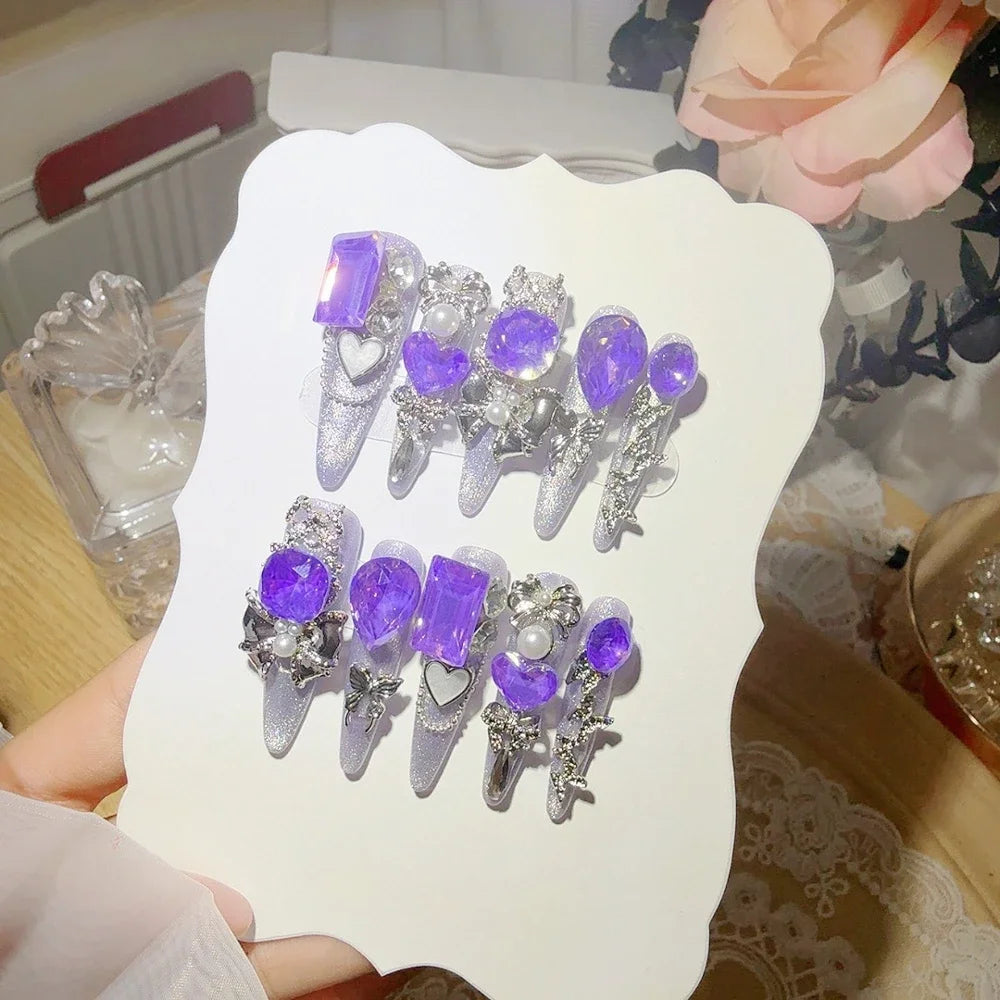 Decorated press-on nail sets with raised embellishments on display cards