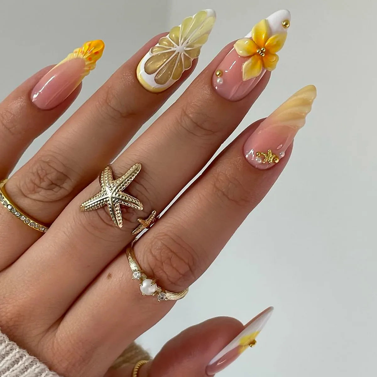 Yellow and pink floral nails shown on a hand