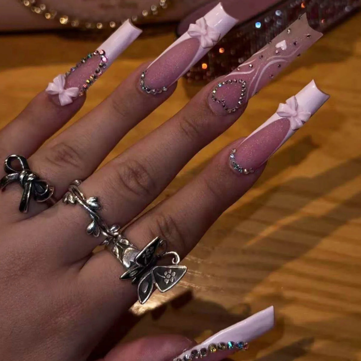 Long decorated nails with raised embellishments shown on hands