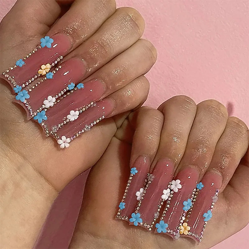 Decorative nail designs with floral, metallic or gem accents shown on hands